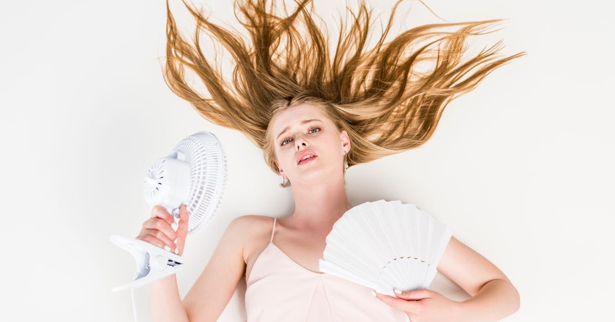 ragazza distesa sul letto che soffre il caldo