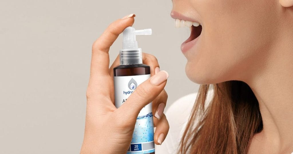 ragazza spruzza in bocca un Colloidale Puro