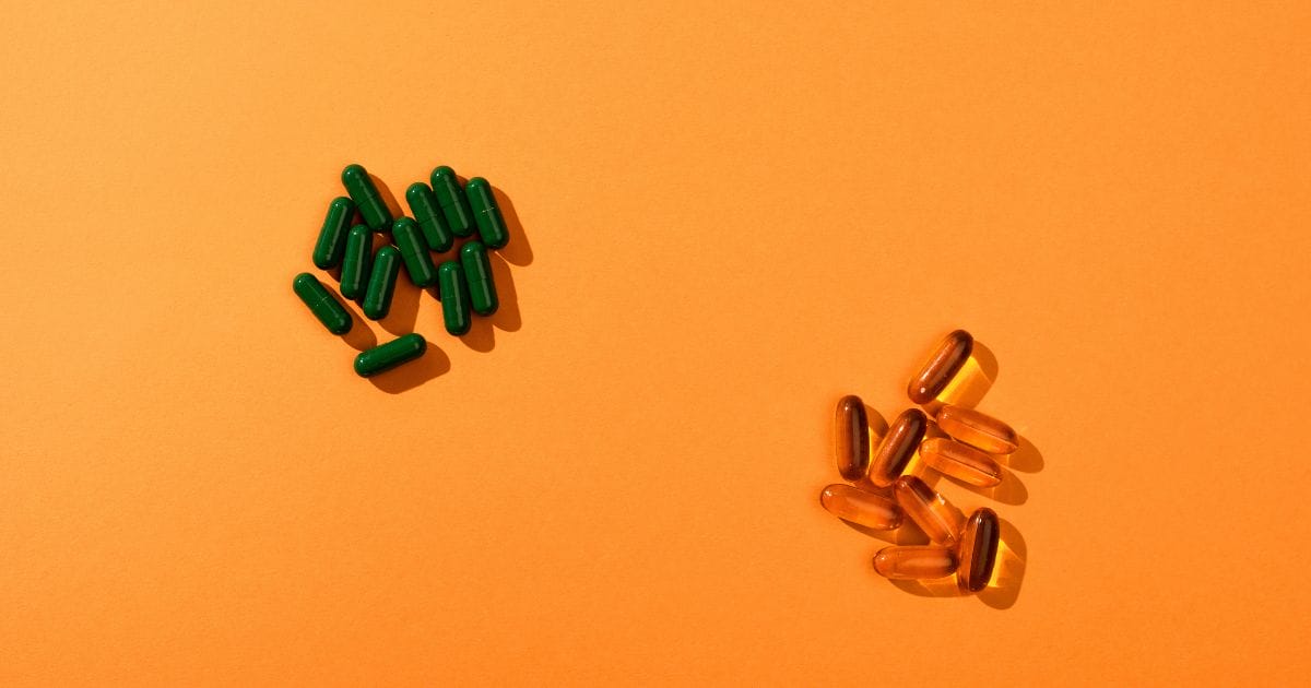 integratori in pastiglie su sfondo arancione